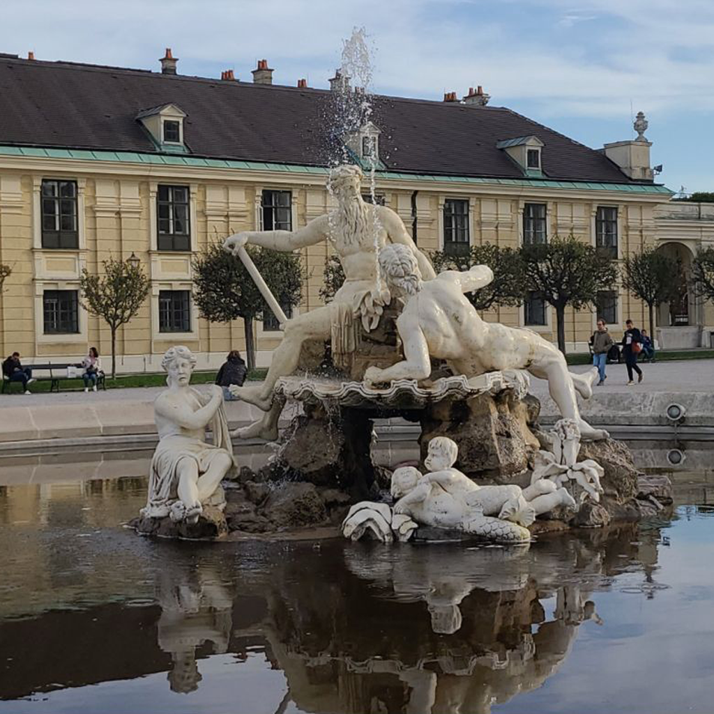 South Beach Deco Drive with colorful Art Deco buildings, palm trees lining the street, and a clear blue sky during daytime